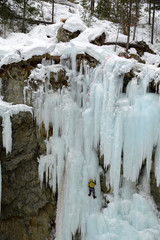 une personne escaladant une cascase de glace