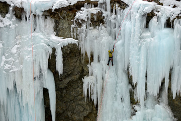 une personne escaladant sur une cascade de glace 
