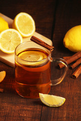 A mug with hot tea with lemons and cinnamon sticks	