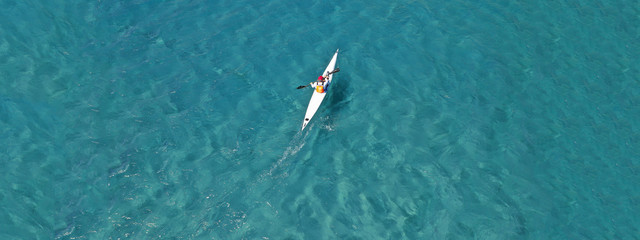 Aerial drone ultra wide photo of fit men competing in sport canoe in tropical exotic bay with...