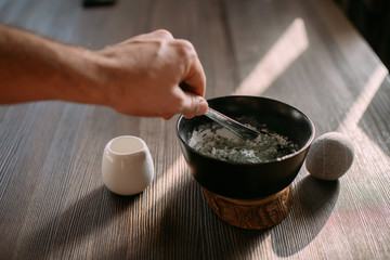 Face and body care. Preparation of a cosmetic mask in a bowl on a table