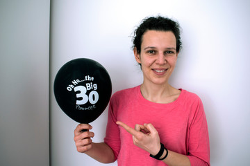 Woman holding a birthday balloon with sign "The big 30"