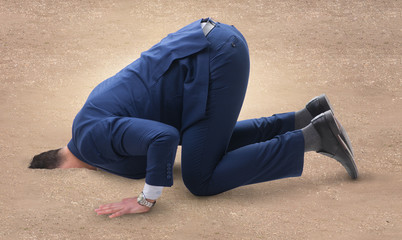 Businessman hiding his head in sand escaping from problems