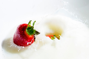 strawberries splashing in milk