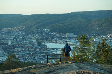 Standing on a mountain and looking at the city down.