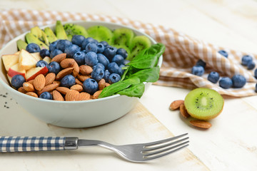Bowl with tasty salad on white table