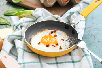 Frying pan with cooked egg on table