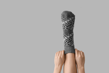 Leg of woman in sock on grey background