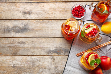 Mason jars of cold tea on wooden table