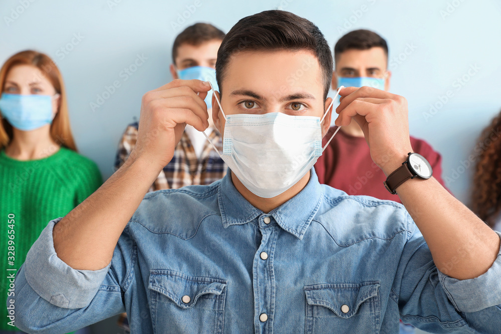 Wall mural Young man wearing protective mask. Concept of epidemic