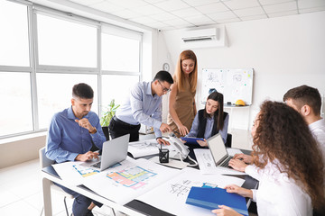 Architect teaching young people in office