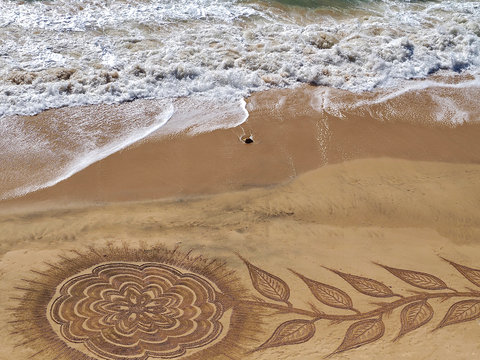 Beautiful beach mandala with a flower and dolphins in Albufeira in Portugal