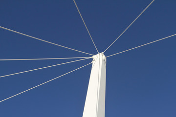 Fototapeta premium white steel cables hold a white pilot straight with a blue sky as the background