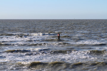a road sign in the sea says that pedestrians are not allowed there.