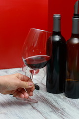 botellas de vino tinto con sacacorchos, de cantador, corcho y copas de vino sobre una mesa blanca