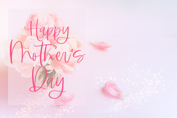 Happy Mother's Day phrase. Fresh bunch of pink peonies and roses in a vase on pink background. Card concept, pastel colors, copy space