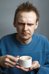Moody man hold cup of coffee