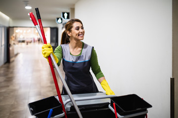 Beautiful young woman cleaning at shopping mall. Cleaning concept. - 328967837
