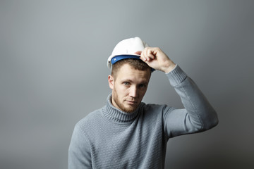 Man puts on a white construction helmet