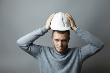 Man puts on a white construction helmet