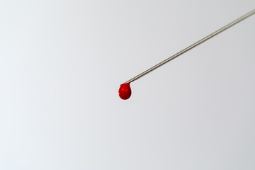 Syringe with a blood sample. A drop of blood at the end of the needle. Blood chemistry. Blood test for viruses.