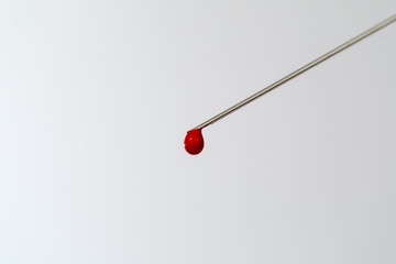 Syringe with a blood sample. A drop of blood at the end of the needle. Blood chemistry. Blood test...