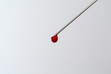 Syringe with a blood sample. A drop of blood at the end of the needle. Blood chemistry. Blood test...