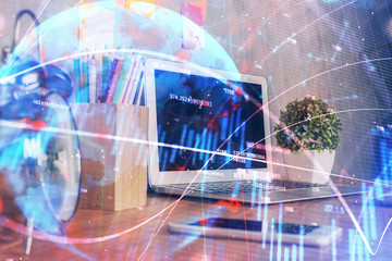 Double exposure of chart and financial info and work space with computer background. Concept of...