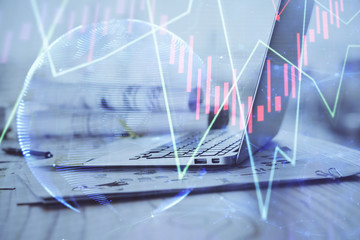 Stock market graph on background with desk and personal computer. Double exposure. Concept of financial analysis.