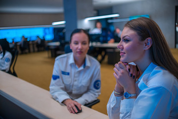 Close up photo of a security female agent monitoring the CCTV in a main data center office.