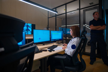 Female security guards working on computers while sitting in the main control room