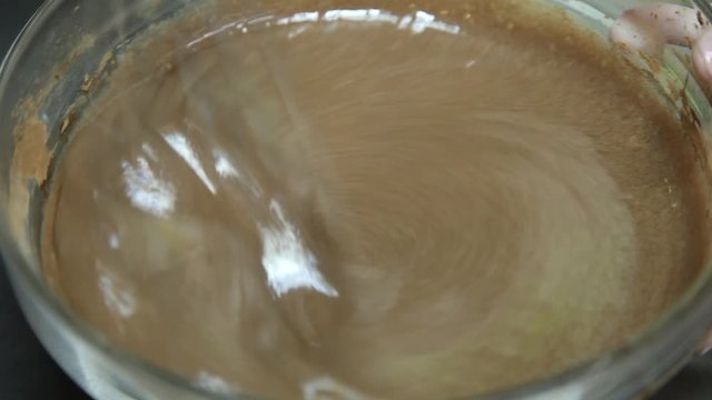 Confectioner mixing chocolate using fouet