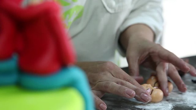 confectioner making figure from sugar paste fondant cake pastery