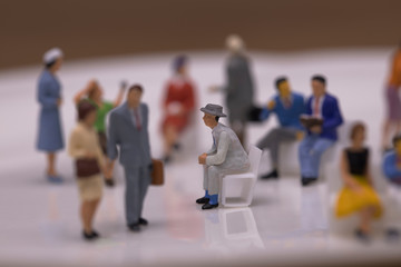 雑踏の中に埋もれる一人で座るビジネスマン