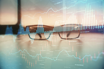 Financial graph hologram with glasses on the table background. Concept of business. Double exposure.