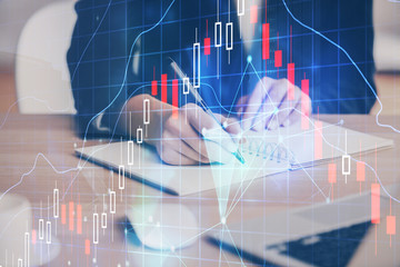 Forex graph on hand taking notes background. Concept of research. Multi exposure