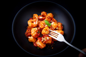 Gnocchi with tomato sauce and garnshied basil and cheese