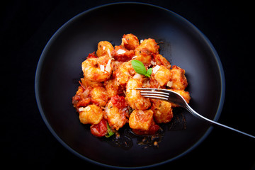 Gnocchi with tomato sauce and garnshied basil and cheese