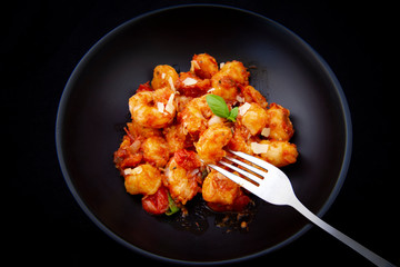 Gnocchi with tomato sauce and garnshied basil and cheese