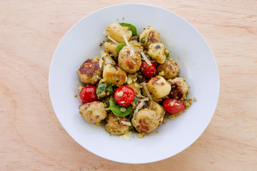 Gnocchi and chicken meatballs with pesto sauce, basil, tomatoes and nuts