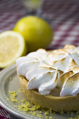 pie de limon con merengue y limones en fondo