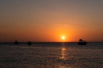 Fototapeta na wymiar sunset on the beach with boats