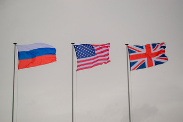 State flags of Russia, USA, Great Britain. Colors - blue, white, red. Background - cloudy sky. Concept of alliance in the Second World War.