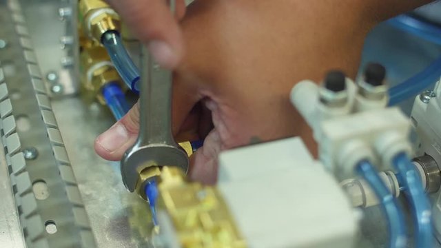 tighten brass nut with wrench in pneumatic automation system