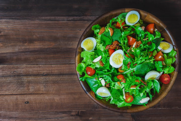food background of vegetable salads with quail eggs on wooden table