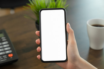 Hand holding blank screen of smartphone on the desk office and for graphic display montage.