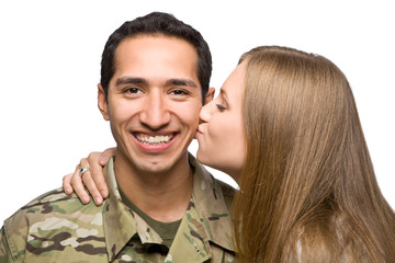 Happy Army soldier getting a kiss from his girlfriend.