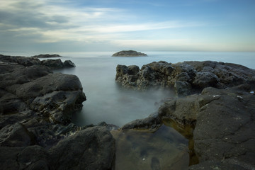 Fototapeta na wymiar long exposure cliffs sea and blue sky
