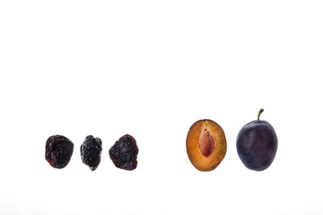 fresh and dried prune plums on white background with copy space above