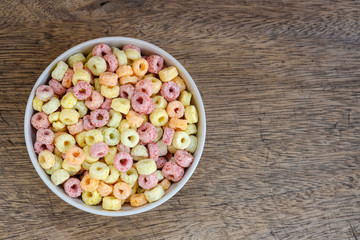Cereal flakes in bowl with copy space,Breakfast concept.Food with delicious fruity taste and fruity colours.It's made with maize,wheat,and barley.topview and copy space.white background
